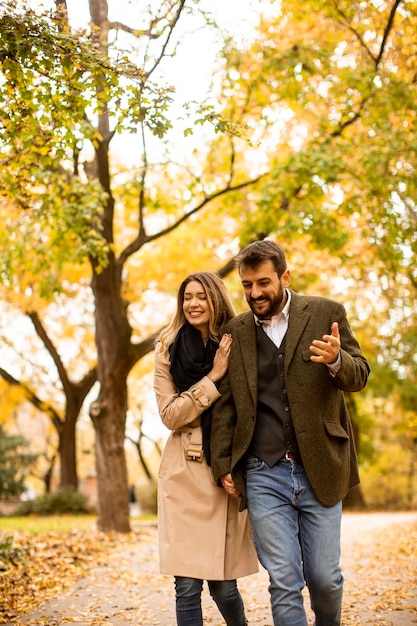 Pareja joven caminando en el parque otoño