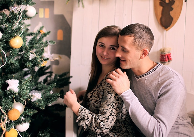 Pareja joven en casa con decoración navideña