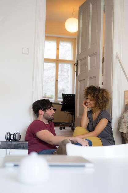 Foto pareja joven en casa relajándose y hablando