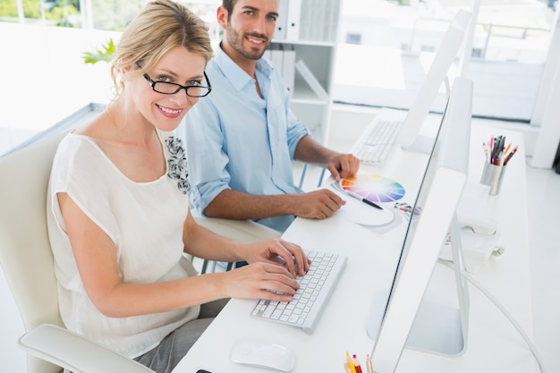 Pareja joven casual trabajando en computadoras