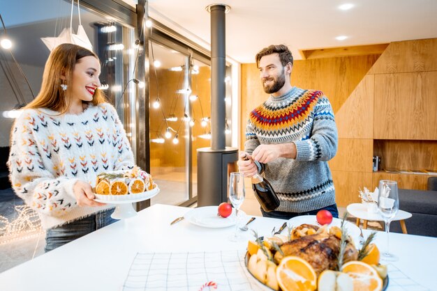 Pareja joven cenando juntos en la casa moderna durante las vacaciones de invierno