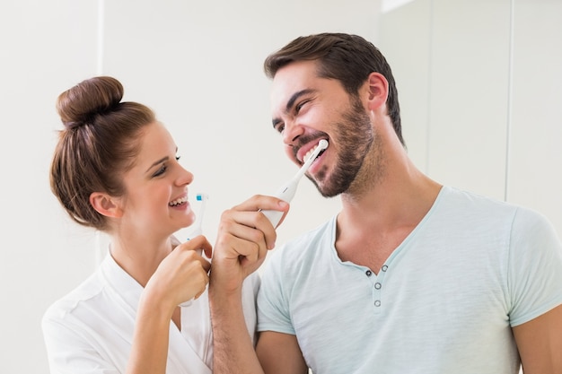 Pareja joven cepillándose los dientes