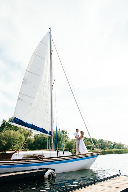 Pareja joven chico y chica en un velero blanco