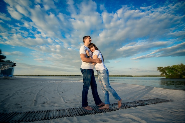 Pareja joven cita romántica en la playa de arena.