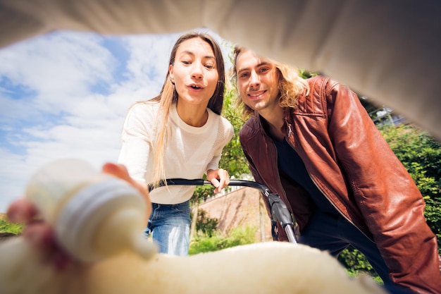 Foto pareja joven con cochecito al aire libre