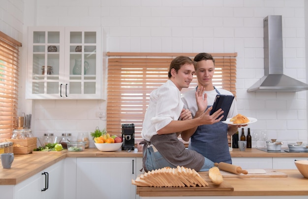 Una pareja joven va a la cocina y aprende a hornear galletas en línea hacerlo y jugar felizmente