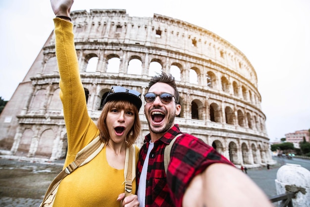 Pareja joven en el Coliseo, Roma - Felices turistas visitando el famoso monumento italiano - Amigos disfrutando de vacaciones en Italia - Vacaciones y concepto de estilo de vida feliz