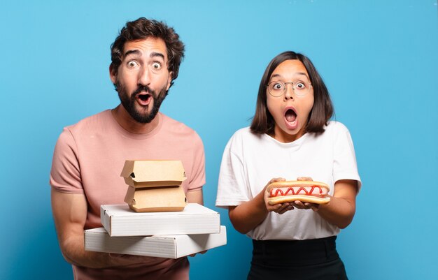 Pareja joven con comida rápida para llevar a casa.