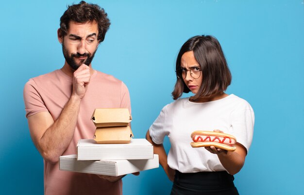 Pareja joven con comida rápida para llevar a casa.