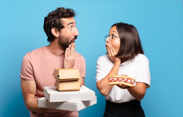 Pareja joven con comida rápida para llevar a casa.