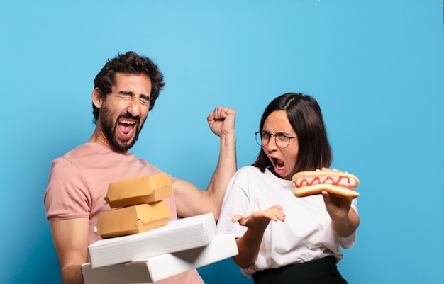 Pareja joven con comida rápida para llevar a casa.