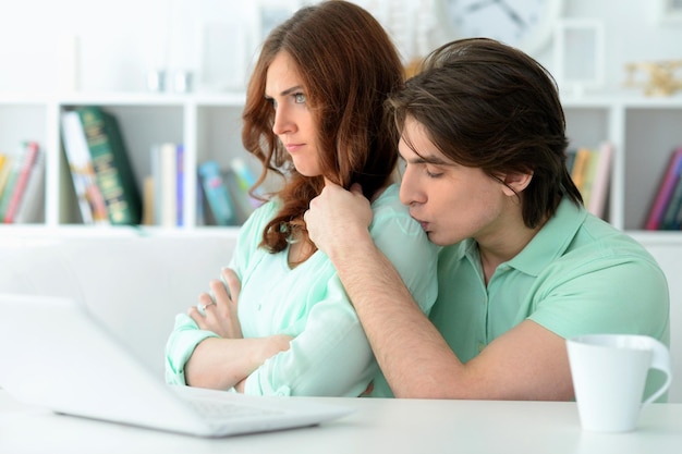 pareja joven, con, computador portatil, en casa