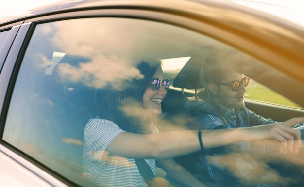 Foto una pareja joven conduciendo un coche.