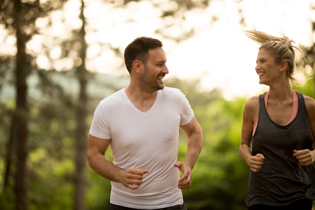 Pareja joven corriendo al aire libre en la naturaleza