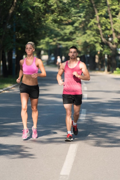 Pareja joven corriendo en el área boscosa del bosque - Entrenamiento y ejercicio para la resistencia del maratón Trail Run - Fitness Concepto de estilo de vida saludable