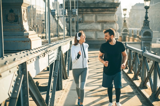 Pareja joven corriendo en el entorno urbano