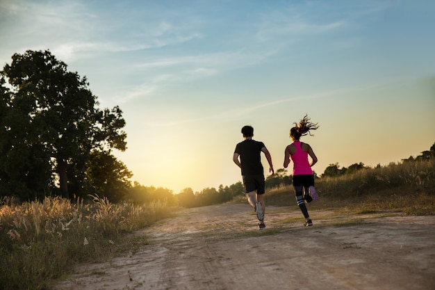 Foto pareja joven corriendo en pista forestal