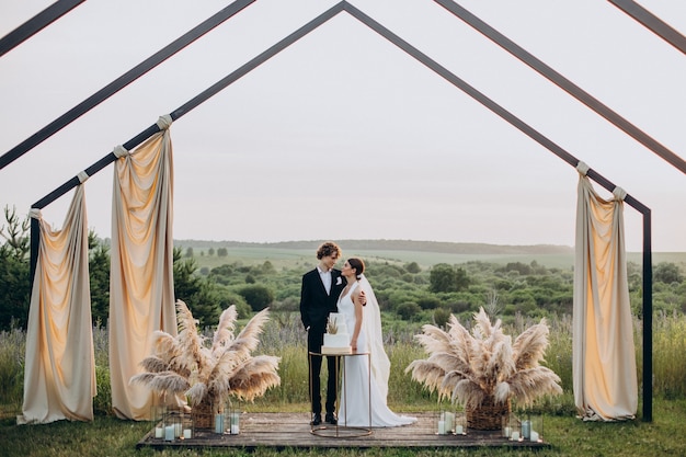 Pareja joven cortando su pastel de bodas