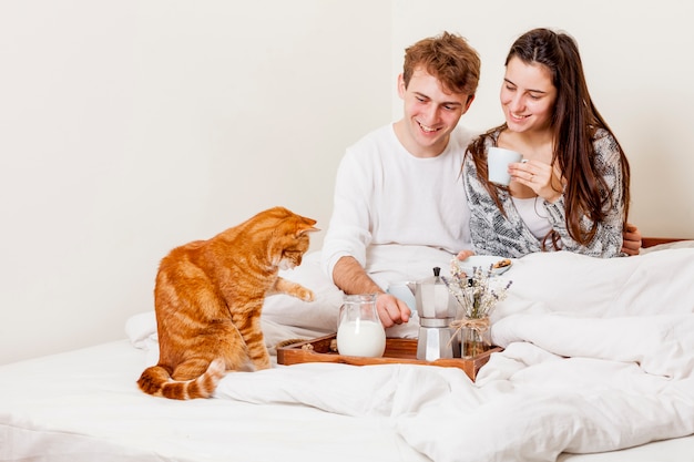 Pareja joven desayunando en la cama