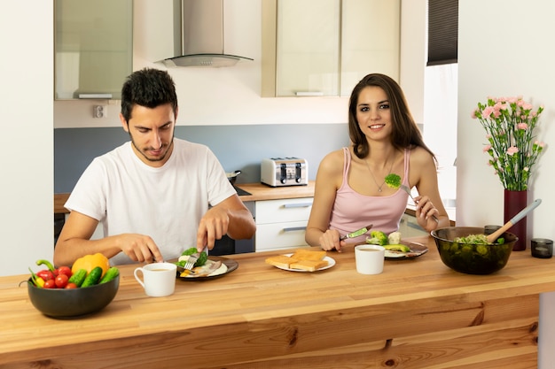 Pareja joven desayunando en casa