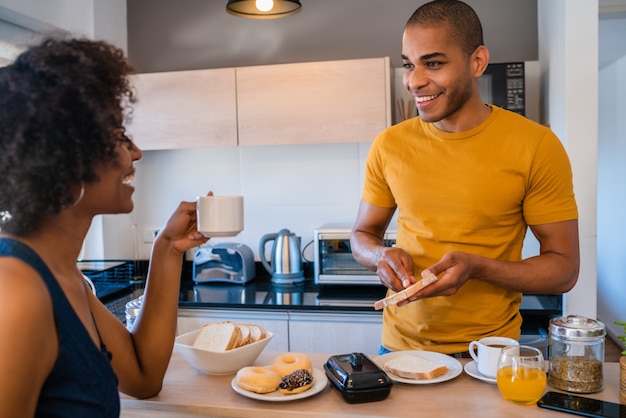 Pareja joven desayunando en casa.