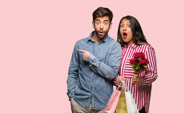 Foto pareja joven en el día de san valentín apuntando hacia el lado