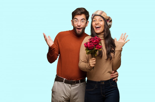 Pareja joven en el día de San Valentín celebrando una victoria o éxito