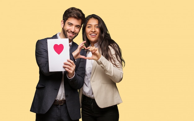 Pareja joven en el día de San Valentín haciendo una forma de corazón con las manos