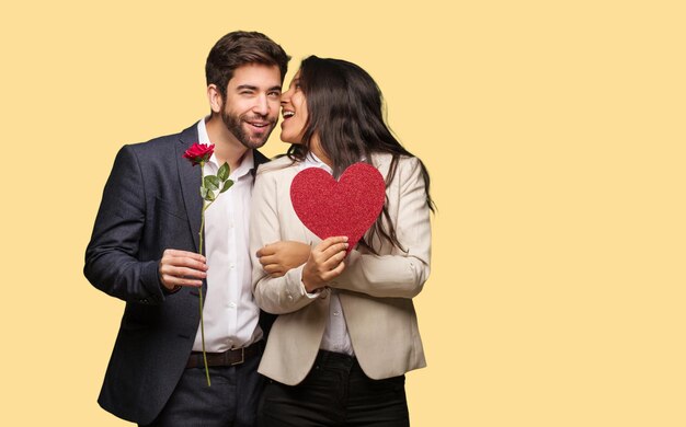 Foto una pareja joven en el día de san valentín susurrando chismes en voz baja