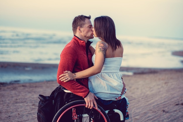 Pareja joven discapacitada descansando en una playa.