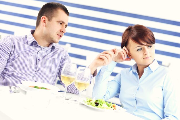 Una pareja joven discutiendo en un restaurante.