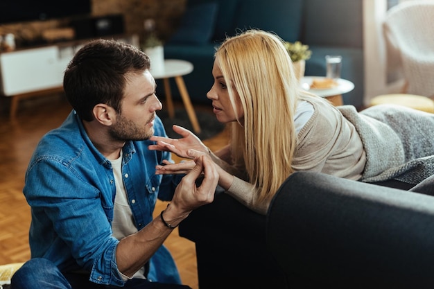 Pareja joven discutiendo sobre problemas en su relación en casa