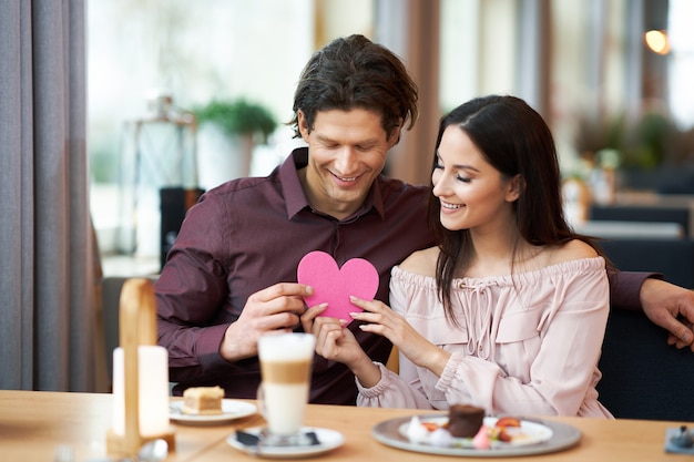 Pareja joven disfrutando de un café y un pastel en el café