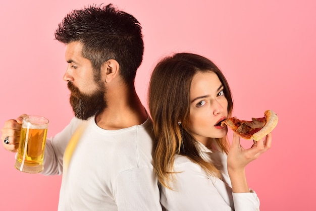 Pareja joven disfrutando de comer pizza hermosa chica mantenga rebanada de deliciosa pizza hombre barbudo guapo