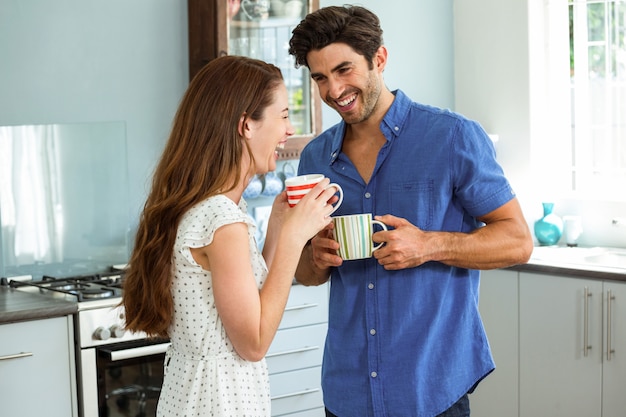 Pareja joven disfrutando mientras tomando una taza de café