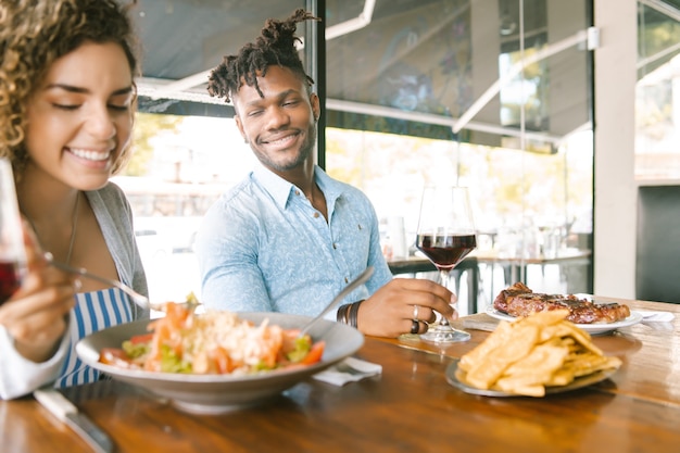 Foto pareja joven disfrutando y pasando un buen rato mientras almuerzan juntos en un restaurante. concepto de relación.