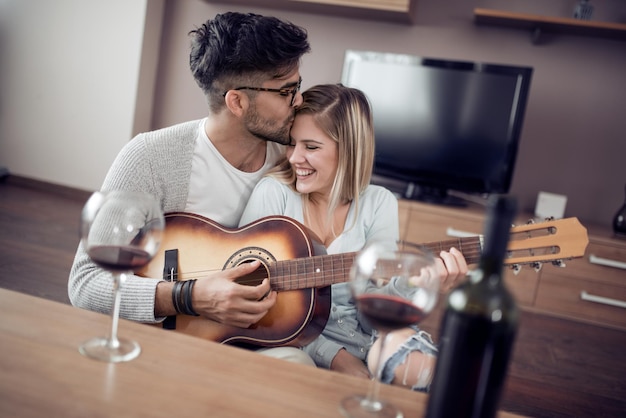 Pareja joven disfrutando del vino en casa