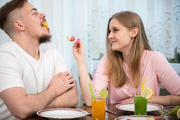 Una pareja joven y divertida pasa el tiempo desayunando.
