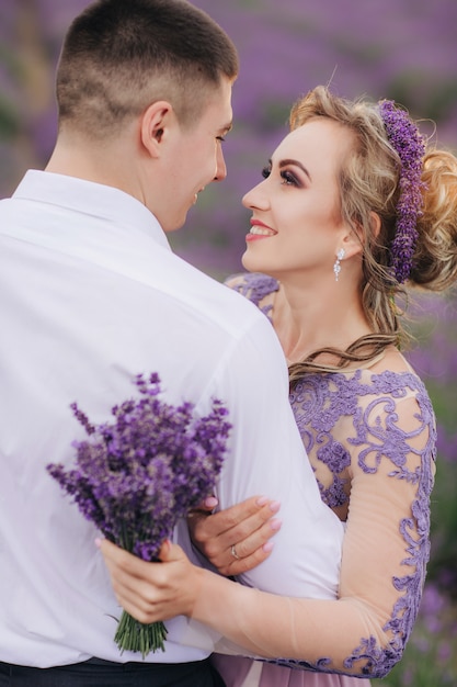 Pareja joven divirtiéndose en un campo de lavanda en un día de verano