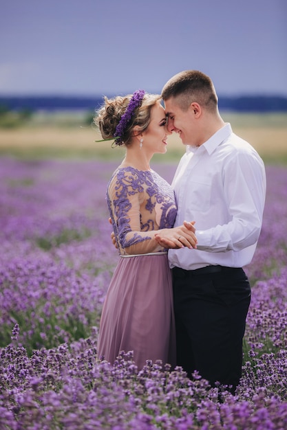 Pareja joven divirtiéndose en un campo de lavanda en un día de verano