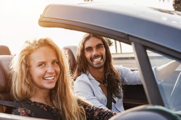 Pareja joven divirtiéndose en coche descapotable en vacaciones de verano - Centrarse en la cara del hombre