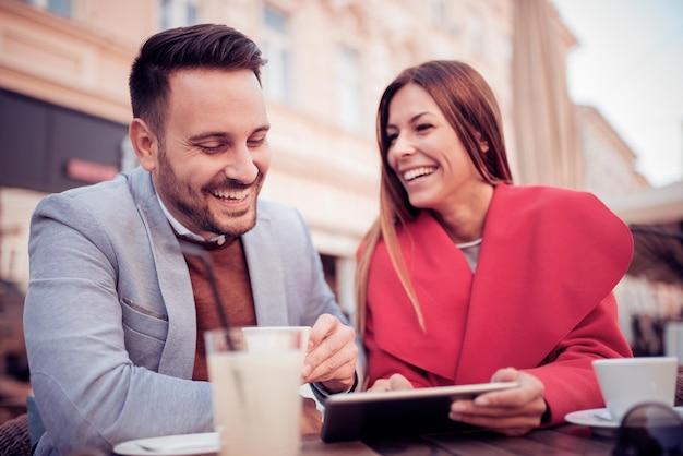 Pareja joven divirtiéndose mientras están sentados juntos en un café de la ciudad