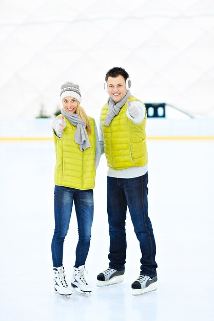 pareja joven divirtiéndose en una pista de hielo