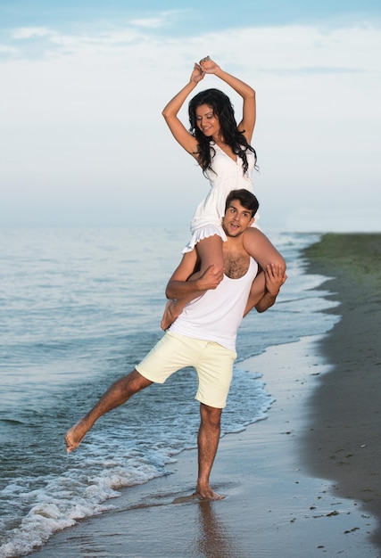 Foto pareja joven divirtiéndose en la playa