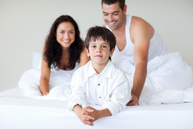 Pareja joven e hijo jugando en la cama