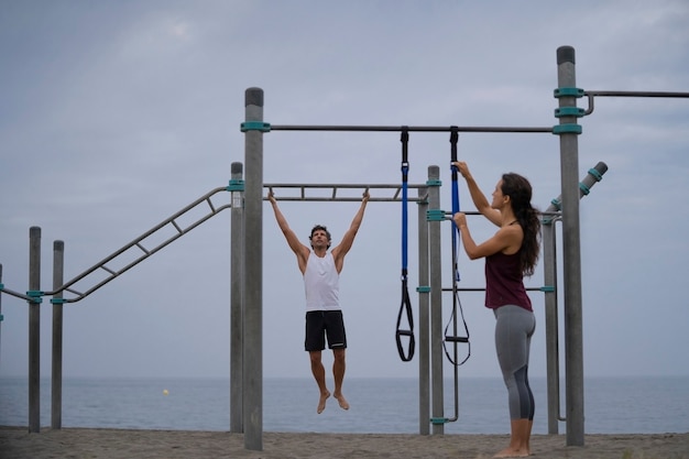 pareja joven, ejercitar, en la playa