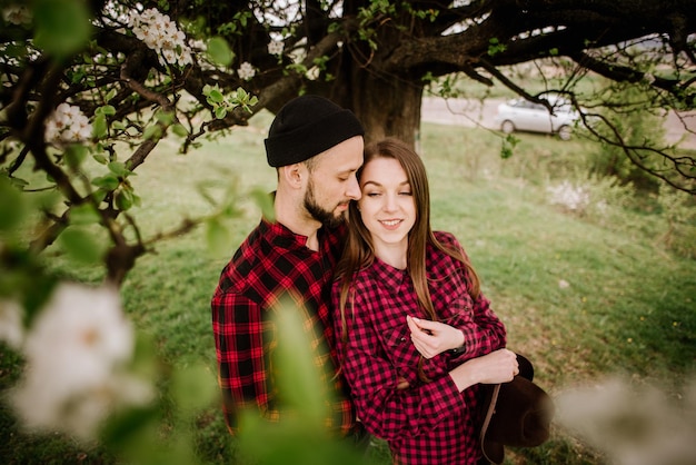 Una pareja joven enamorada se abraza bajo el árbol floreciente