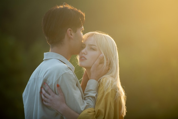 Una pareja joven enamorada se abraza. Historia de amor. Amantes de la pareja abrazándose y besándose al atardecer.