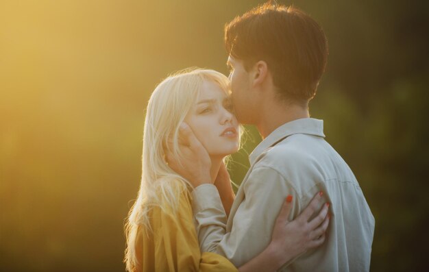 Pareja joven enamorada se abrazan Historia de amor Amantes de la pareja abrazándose y besándose al atardecer