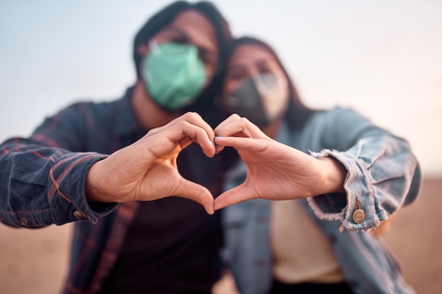 Una pareja joven enamorada camina por la playa durante una hermosa puesta de sol